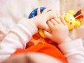 Małe rączki bawią się kolorowymi zabawkami. Dziecko odkrywa świat, a "a kuku zabawki" towarzyszą mu w tej przygodzie.