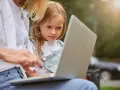 Mama z córką przeglądają internet, szukając informacji, kiedy jest rekrutacja do żłobka.