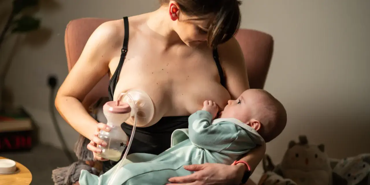 Kobieta karmi piersią dziecko, jednocześnie używając laktatora Tommee Tippee do odciągania mleka.