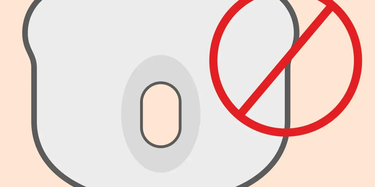 Zakaz używania poduszki ortopedycznej dla noworodka. Czerwone koło z przekreśleniem na jasnoszarym tle.