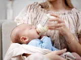 Mama karmi maluszka z butelki, która może być najlepszą butelką antykolkową dla noworodka.