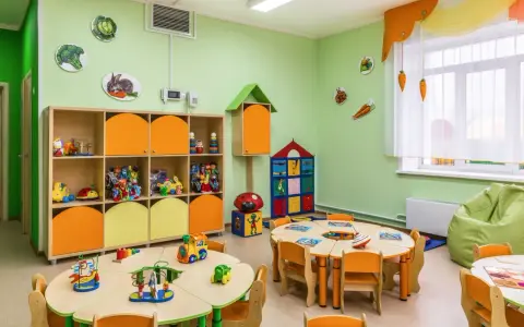 Kolorowy żłobek z zabawkami i stolikami. Czy żłobek jest płatny? To zależy od placówki, ale tutaj dzieci bawią się wesoło.