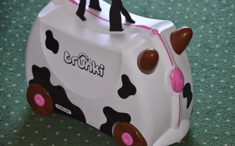 Biała trunki walizka dla dzieci w kształcie krowy z czarnymi łatami i brązowymi rogami. Idealna na podróże!