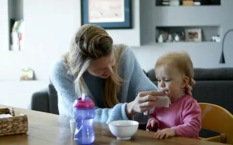 Opiekunka wyciera buzię dziecka. Zastanawiasz się, ile biorą opiekunki do dzieci za taką troskę?