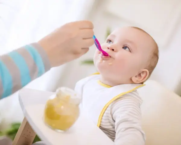 Maluch z zaciekawieniem przyjmuje pierwszą łyżeczkę. Ranking najlepszych pierwszych łyżeczek dla niemowlaka.
