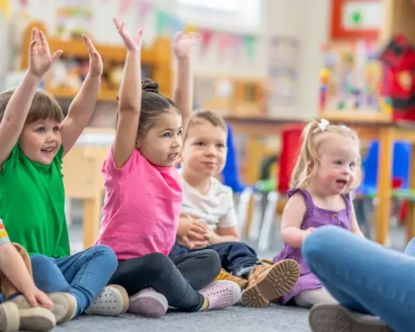 Dzieci na zajęciach w przedszkolu, z podniesionymi rękami. Czy z owsikami można iść do przedszkola? Nie, w przypadku owsików dziecko powinno zostać w domu.