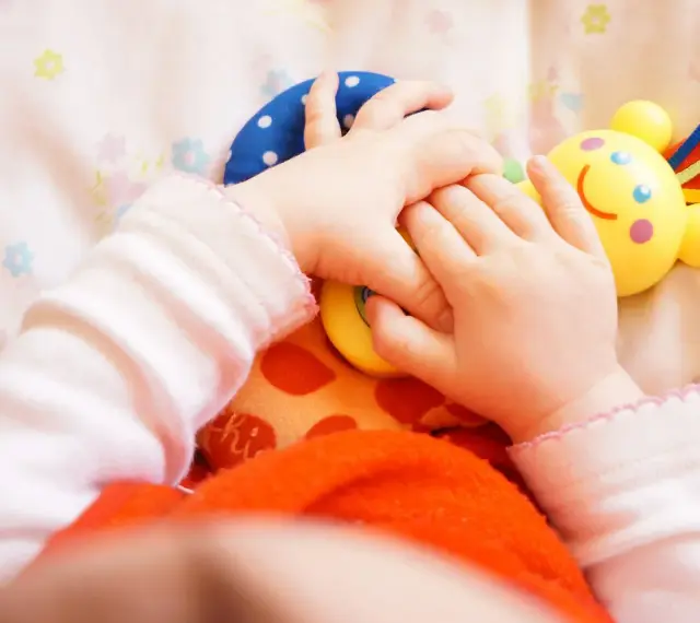Małe rączki bawią się kolorowymi zabawkami. Dziecko odkrywa świat, a "a kuku zabawki" towarzyszą mu w tej przygodzie.