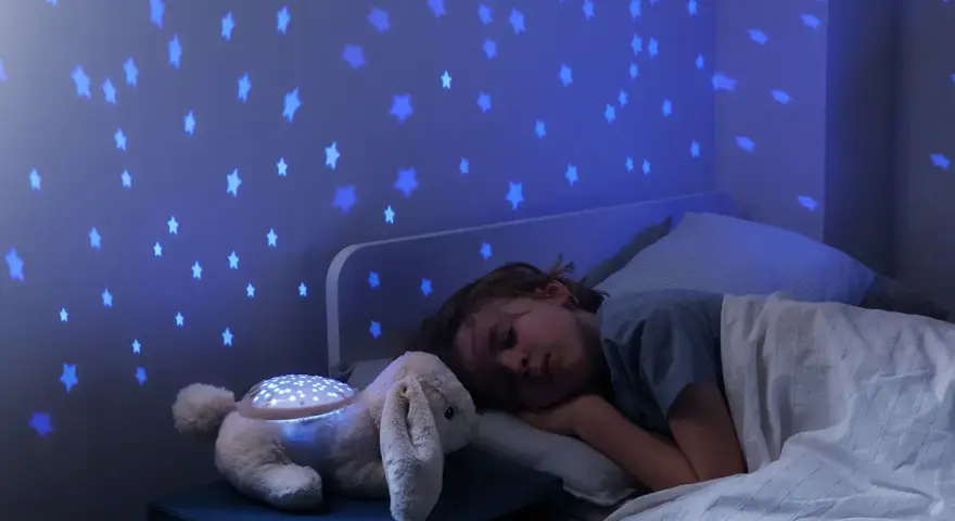 Uroczy króliczek z projektorem dla niemowlaka rzuca na ścianę niebieskie gwiazdki, tworząc magiczną atmosferę do snu.