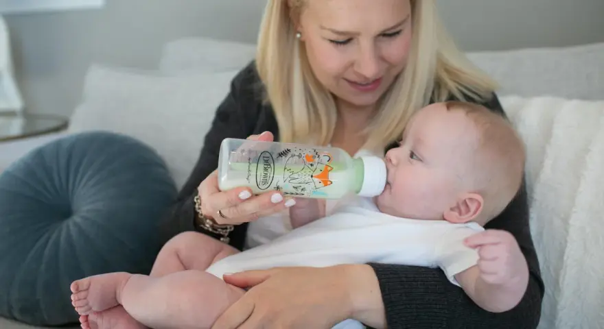 Mama karmi dziecko z butelki antykolkowej Dr Brown's z uroczym motywem lisów.