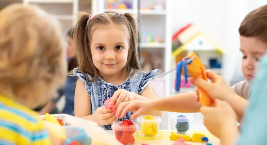 Dzieci bawią się plasteliną. Ile pieniędzy dostaje przedszkole na dziecko z orzeczeniem?