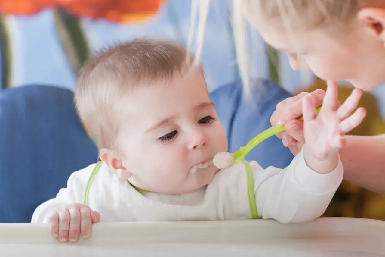 Mama karmi dziecko, które właśnie zaczyna przygodę z jedzeniem. To dla niego pierwsza łyżeczka dla niemowlaka, ranking najlepszych akcesoriów do karmienia.