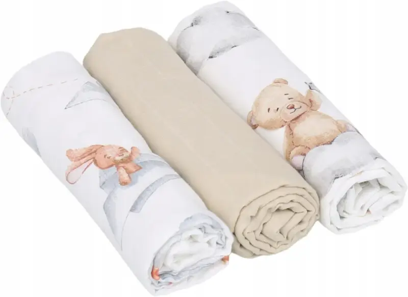 Trzy zwinięte babyono pieluszki muślinowe: dwie z motywem misia i królika, jedna gładka, beżowa.